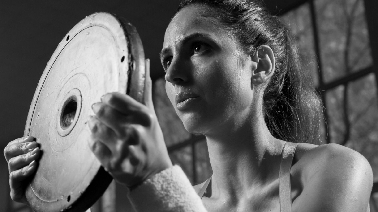 Kobieta ćwicząca z obciążnikiem na siłowni - prawidłowy oddech
